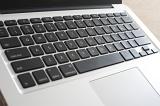 Close up view of open laptop computer featuring black keyboard and silver body
