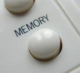 Extreme macro close up on round plastic control button with memory text above it