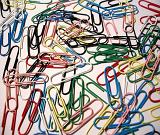 Scattered background of colorful paperclips on a white background viewed from above as a background texture and pattern