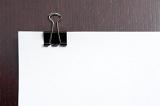 Binder clip on blank white paper with copy space