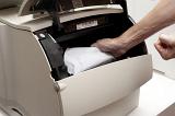 Frustrated man trying to free a copier paper jam and clenching his hand into a fist