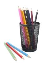 Multicoloured sharpened wooden pencils in a container with a red, blue and green pencil crayon in the foreground