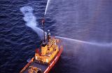 Fireboat on the water spraying high pressure jets of water in a display showing how to douse a blaze
