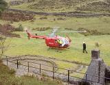 Air ambulance parked in a field with the rotors turning as the medical team respond to an emergency