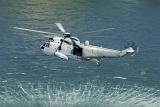 Navy rescue helicopter creating a vortex on the surface of the ocean as it hovers down low during a rescue operation