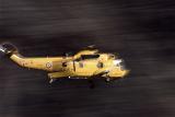 A motion blurred yellow rescue helicopter racing to an emergency