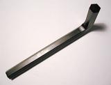 Metallic black L-shaped tool used to work with hexagonal screws, close-up with shadow and copy space on gray