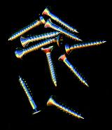 Metallic screws or fasteners with spiral external thread, isolated, with copy space on black