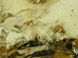 Close up of cream colored abstract glass image with some bubbles and black patches