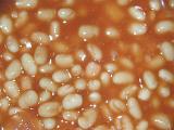 Baked beans in tomato sauce background texture for a healthy quick snack or meal in a full frame closeup overhead view