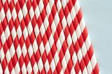 Drinking straw background pattern and texture with colorful spiral red and white straws laid side by side with copy space to the right