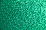 Close up of green knitted sweater with delicate circular pattern