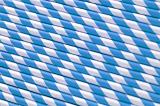 Blue and white straws background pattern with the straws laid side by side in a diagonal orientation for a colorful spiral pattern