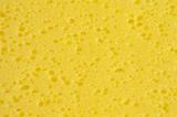 Extreme macro top down close up on various sized porous holes in yellow sponge as full frame background with copy space