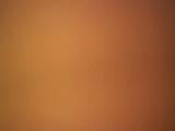 Smooth textured full frame close up dark orange background with vignette and copy space