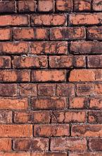 Unusual background with close up view of brick wall facing outside as the sun illuminates it