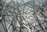 Background composed from extreme close up view of metal wires thrown together against a grey table