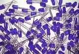 Pile of assorted purple light emitting diodes over white for technology or electronics concepts