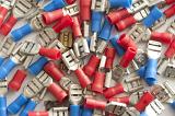 Top down view on pile of scattered low power automobile electrical connectors in red and blue colors