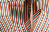 Abstract background of red, orange, yellow, green, blue, purple and black wires in ribbon