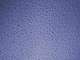 Blue wall surface background with a rough pitted texture and pattern and soft vignette, full frame