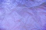 Top down view on purple tissue paper with wrinkles as full frame background with copy space