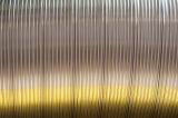 Abstract background composed of ridged metal can with yellow highlights underneath