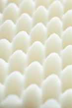 Alternating rows of white rounded soft sponge shipping foam in top down extreme close up