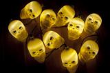 Group of glowing yellow Halloween skull lights over a dark background to celebrate the season of Horror