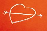 a chalk love heart symbol shot by cupids arrow, concept of romance