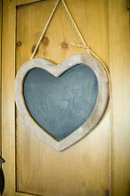 a wooden heart shaped blackboard with room to add a couple of names
