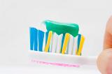 close up on a toothbrush with green toothpaste on it