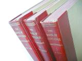 Close Up of Three Old Encyclopedia Book Volumes with Red Leather Spines Standing Side by Side with White Background