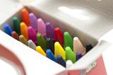 Open box of multicolored wax crayons with focus to the tips in the colors of the spectrum in a artistic, creativity and educational concept