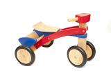 Simple kids wooden toy tricycle with colorful red and blue painted accents isolated on white