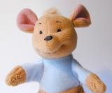 Cute little soft stuffed kangaroo toy with a happy smile wearing a blue jacket, closeup of the head and arms