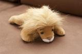 Cute stuffed lion with a blond mane lying on the floor of a kids nursery or playroom, high angle view