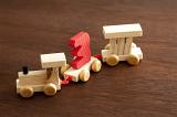 Wooden toy train with the number three in colorful red mounted on a carriage pulled by an engine and wagon for teaching kids counting and arithmetic