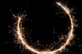 three quarter complete circle of sparks on a black background