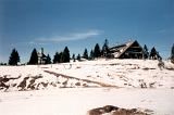 Hilltop Chalet at Mountain Ski Resort with Chair Lift on Sunny Day During Early or Late Season with Sparse Snow Cover