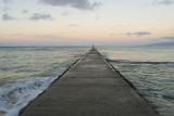 standing at the end of a long jetty looking out to sea at the sunrise, Honolulu, Hawaii