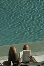 a nice way to relax - reading a book by the pool side