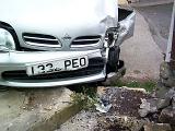 Front grill and bonnet of a white vehicle involved in a road traffic accident with a crunched headlight and side wing