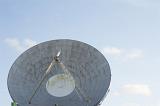 Large parabolic satellite dish or antenna against a sunny blue sky with copy space in a telecommunications concept